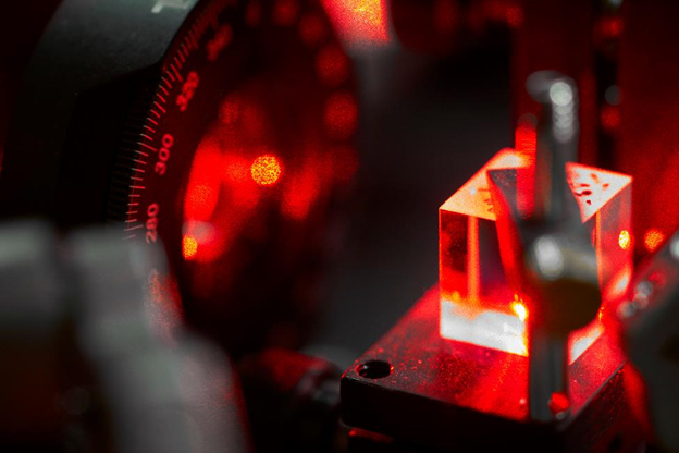 Hänsch Group_Scattered red laser light that shines through a polarizing beam splitter cube as part of a 626nm laser system